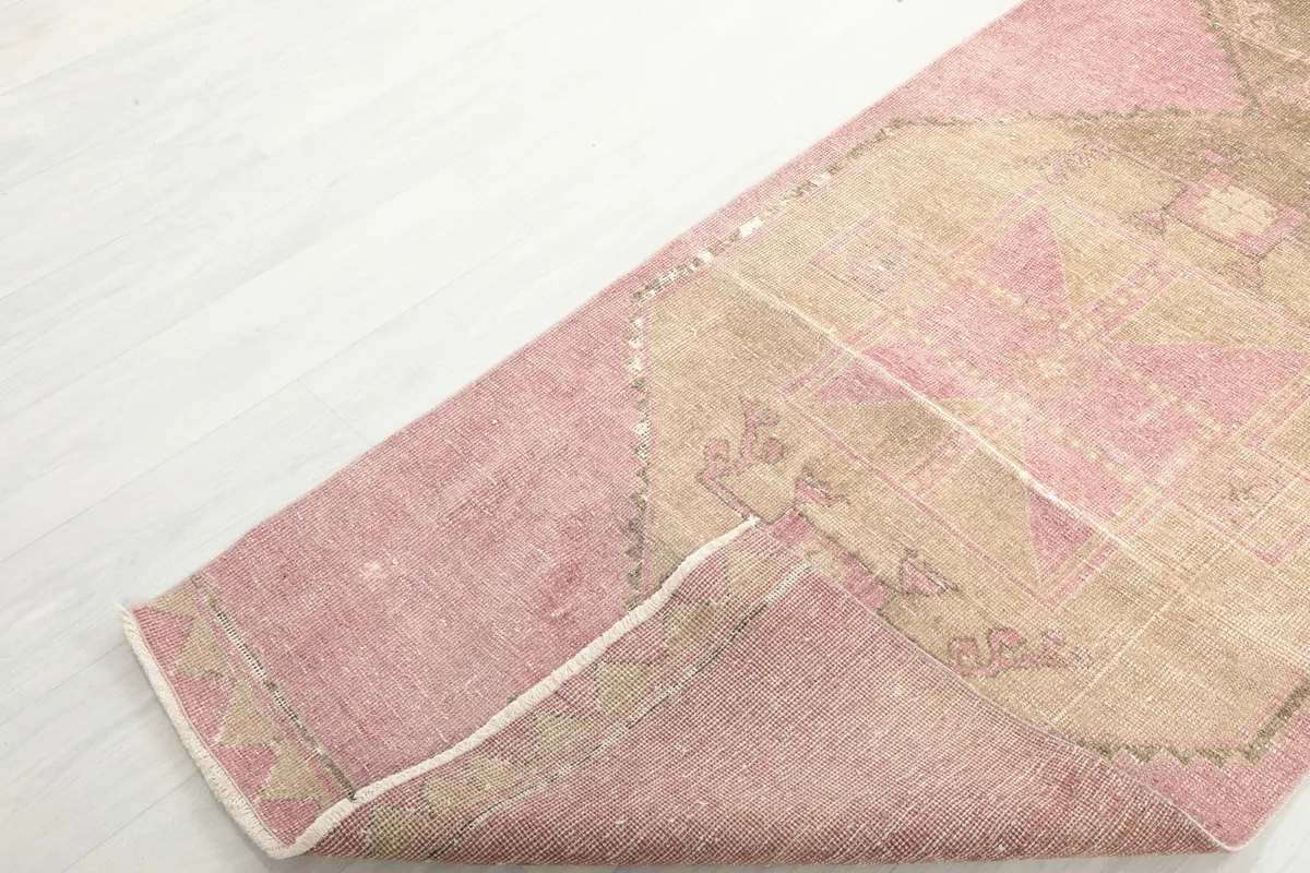 Corner of the runner rug folded back, revealing the wool pile and cotton foundation.
