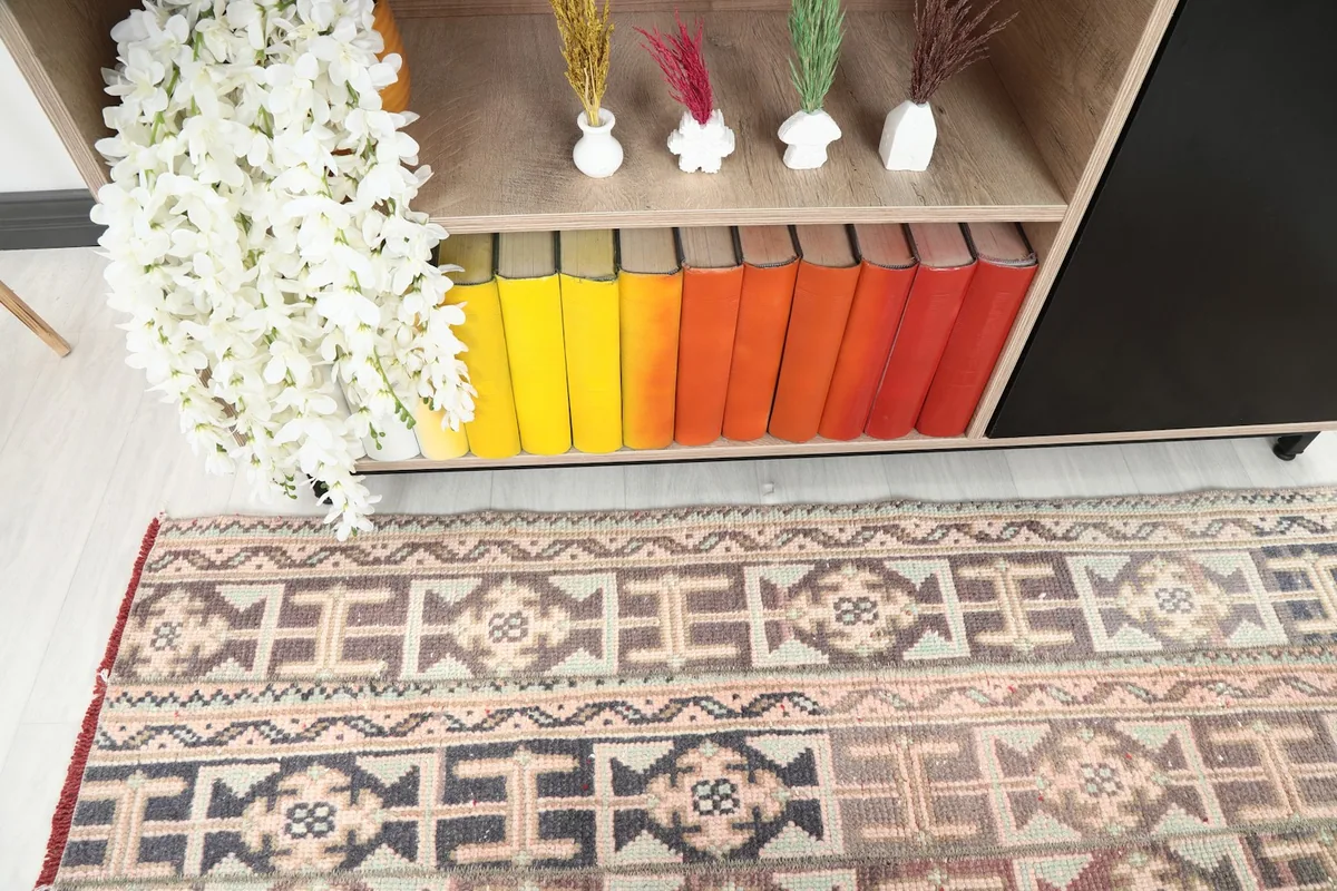 Detailed view of the rug's geometric motifs and colors next to a bookshelf
