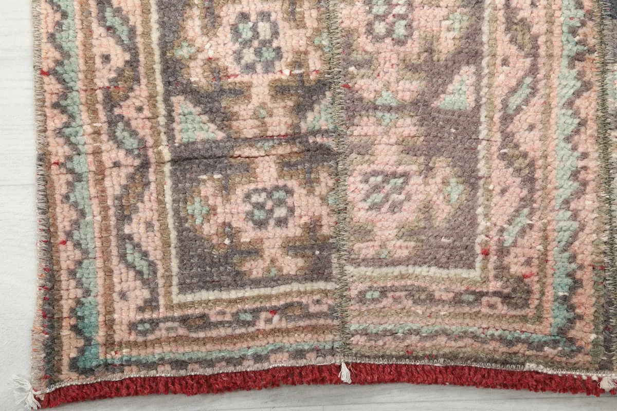 Detail of the rug's end, showing the border pattern and short red fringe