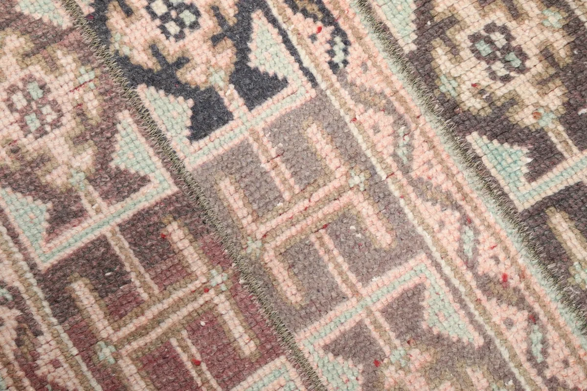 Close-up of the rug's low wool pile, showing individual knots and slight wear