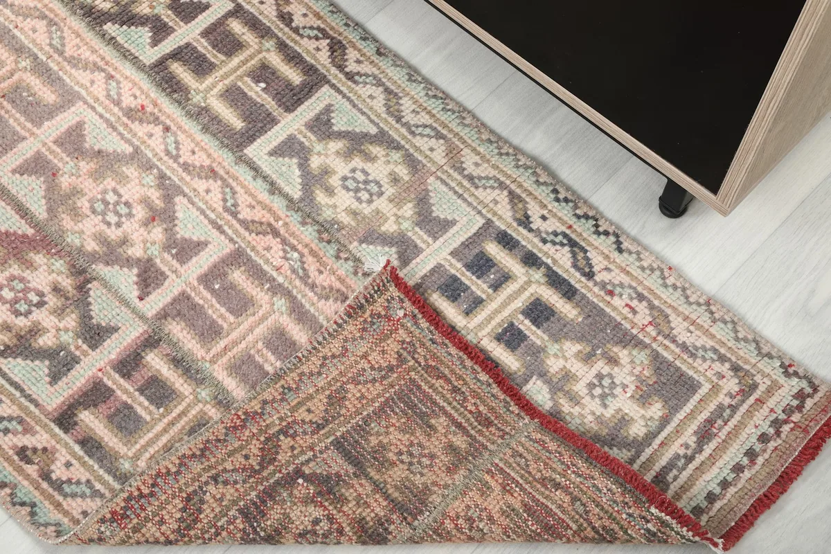 Corner of the rug folded back to reveal the hand-knotted cotton foundation