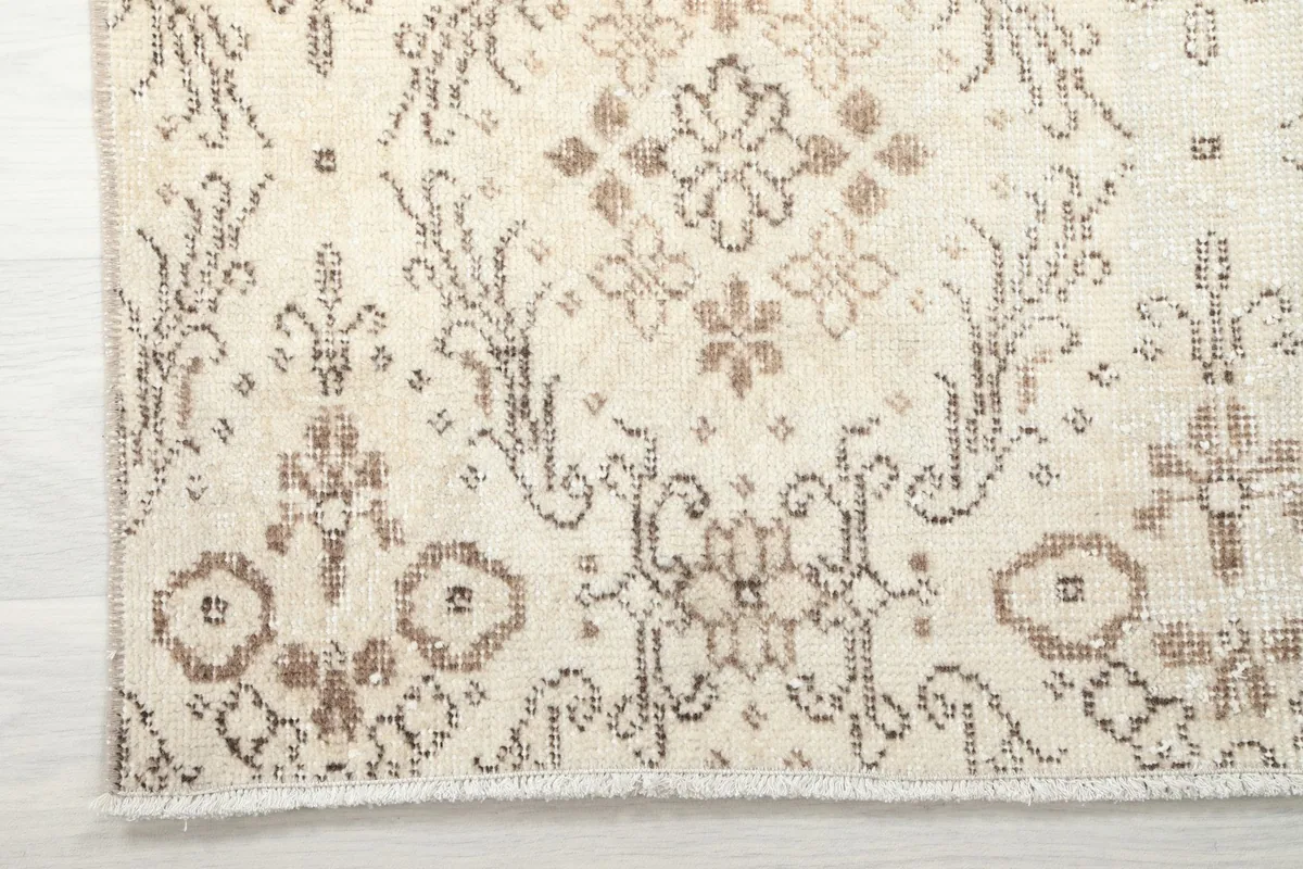 Detailed view of the rug's edge and fringe, showcasing the tightly woven hand-knotted construction.