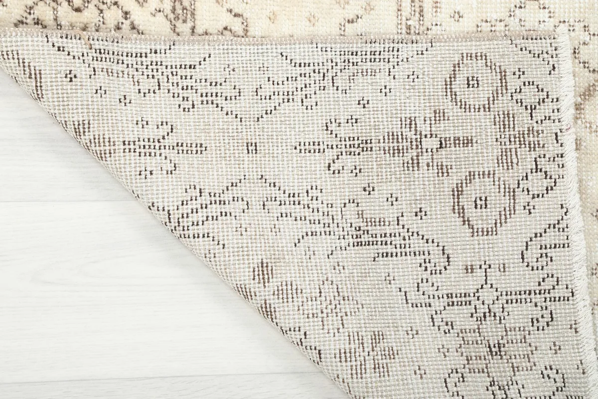 Close-up of the back of the rug, showing the hand-knotted cotton foundation and the reverse of the pattern.