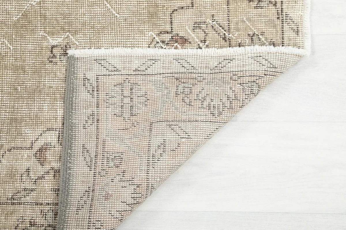 Close-up of the rug's reverse side, revealing the knotting and fringe