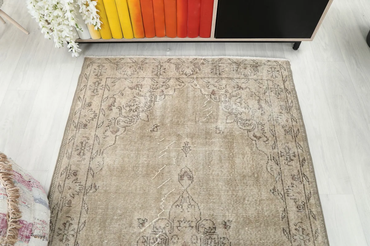 Overhead view focusing on the upper half of the beige rug's pattern