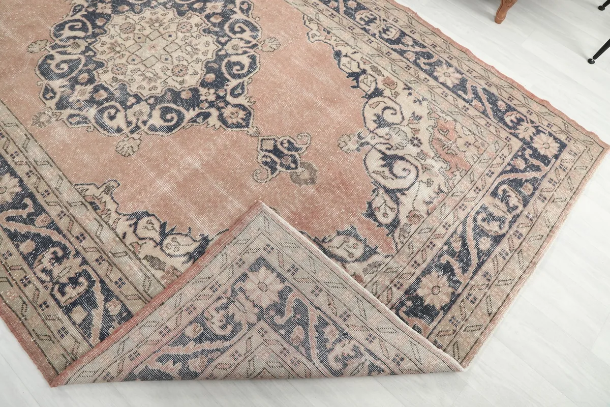 Corner of the rug folded back to reveal the wool pile and cotton foundation