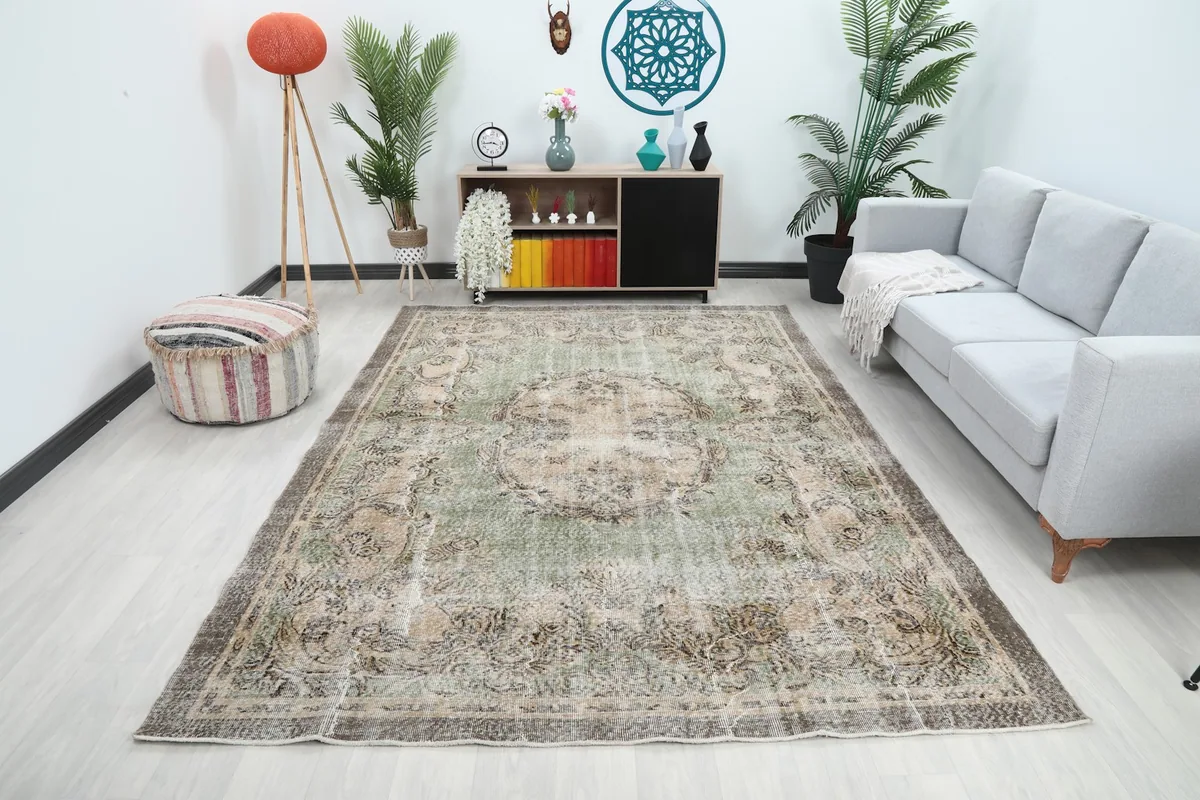Vintage Anatolian area rug displayed in a living room setting with a gray sofa