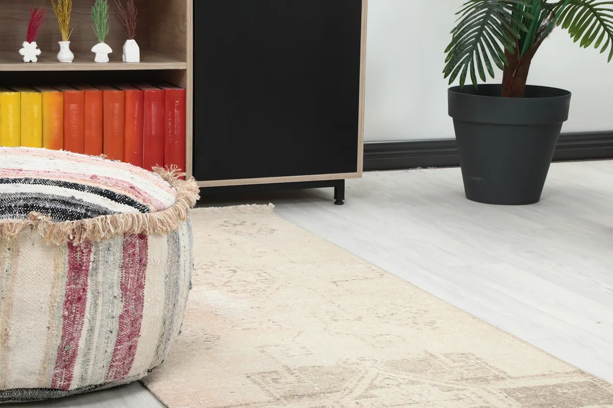 Close-up of the runner rug's pattern and texture next to a decorative ottoman and bookshelf