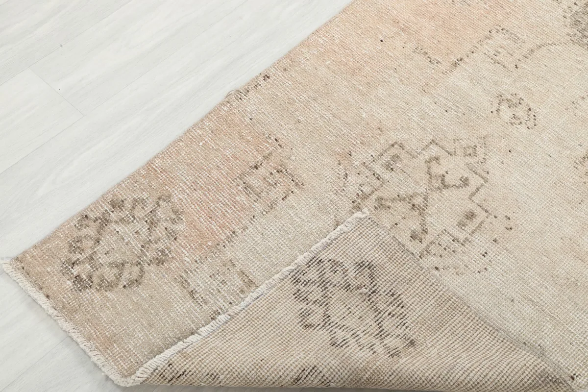 Corner of the rug folded to reveal the hand-knotted wool pile and cotton foundation