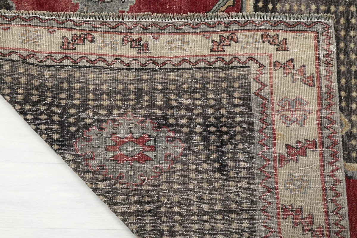 Corner of the rug folded to show the hand-knotted wool pile and cotton foundation
