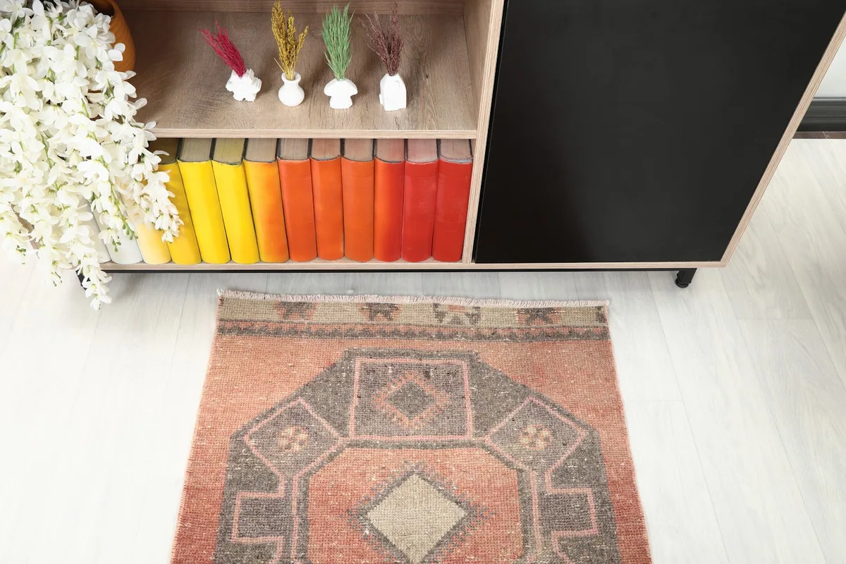 Detailed overhead view of one end of the rust runner rug, showing the geometric pattern and color variations.