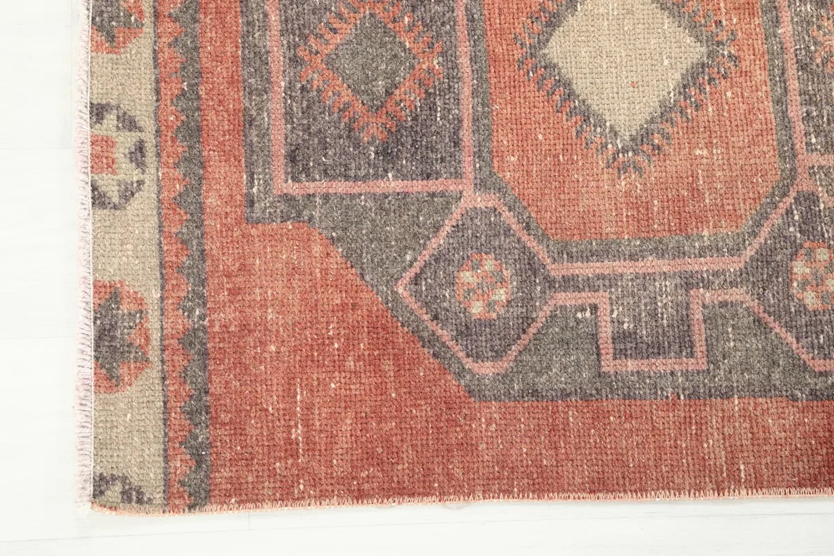 Corner detail of the runner rug, showing the edge finish and the intricate geometric border design.