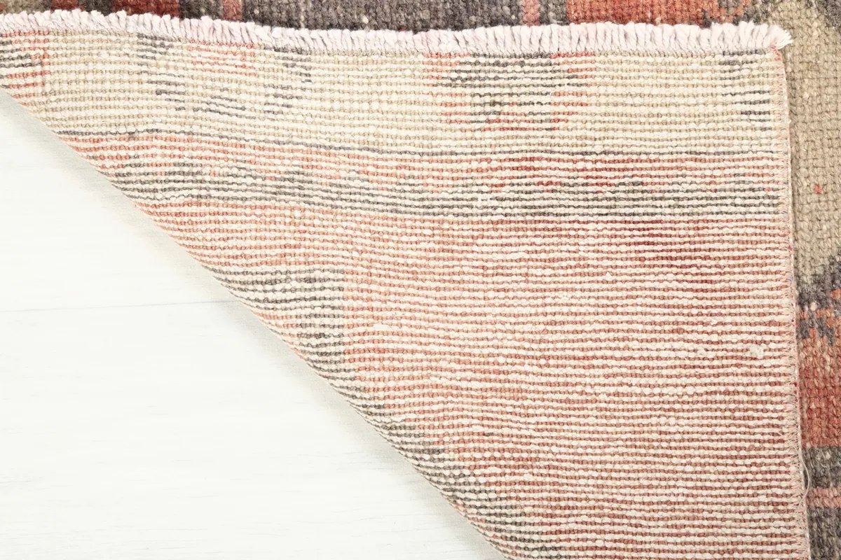 Close-up view of the back of the hand-knotted wool rug, showing the tight weave and cotton foundation.