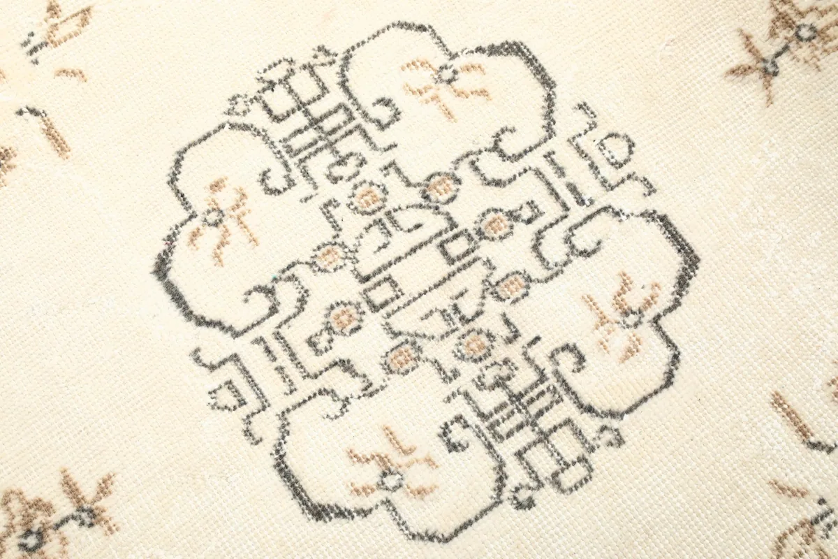 Detailed view of the intricate hand-knotted patterns within the rug's central medallion
