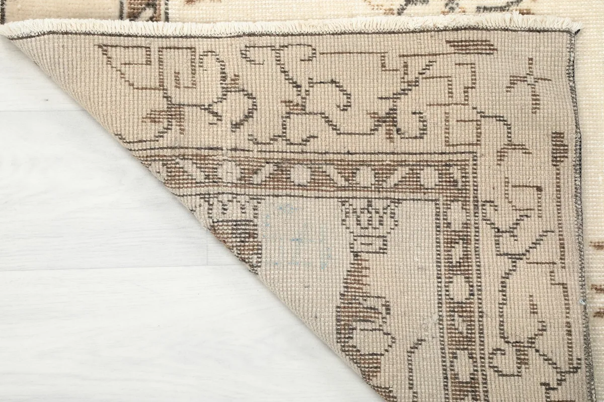 The back of the vintage rug, revealing the hand-knotted cotton foundation and wool pile