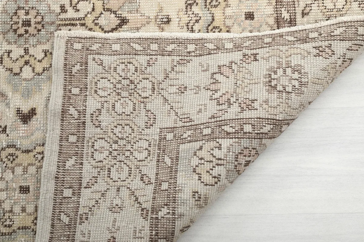 Close-up of the folded corner, revealing the reverse side of the hand-knotted wool rug.