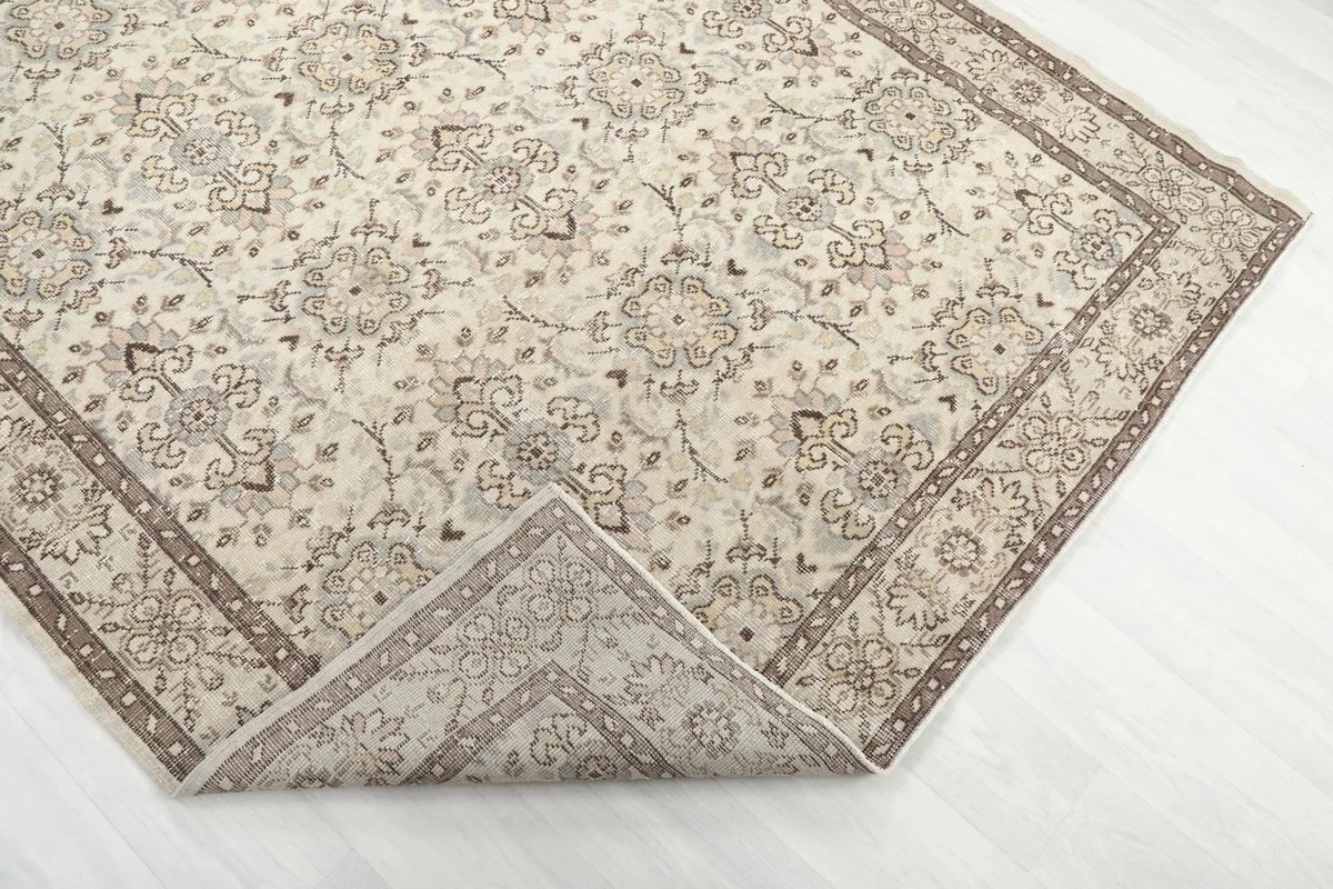 Corner of the rug folded back to show the cotton foundation and hand-knotted construction.