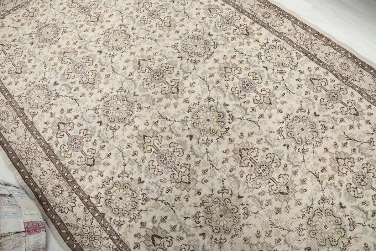 Overhead shot showcasing the full pattern repeat across the beige field of the rug.