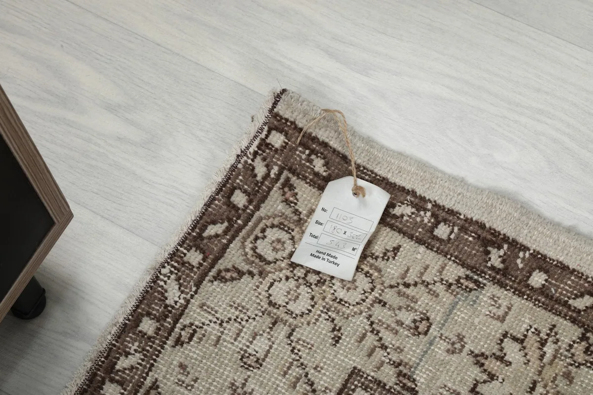 Corner of the rug with the product tag attached, showing the quality and origin details.