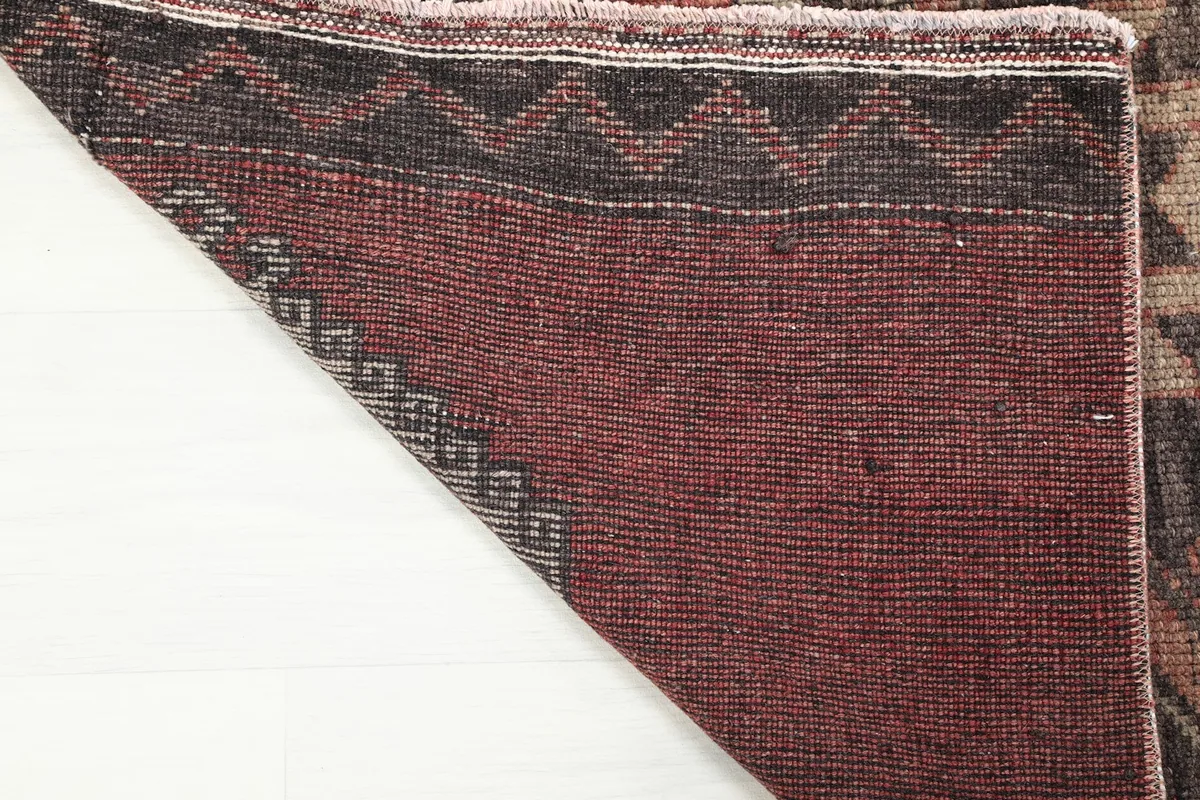 Close-up of the back of the vintage runner rug, showcasing the tight hand-knotting and cotton foundation.