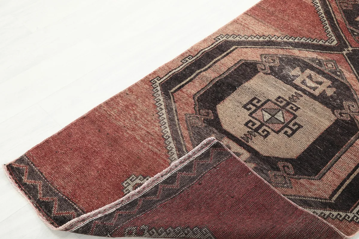 View of the rug folded to reveal the underside and the hand-knotted construction of the wool pile and cotton foundation.