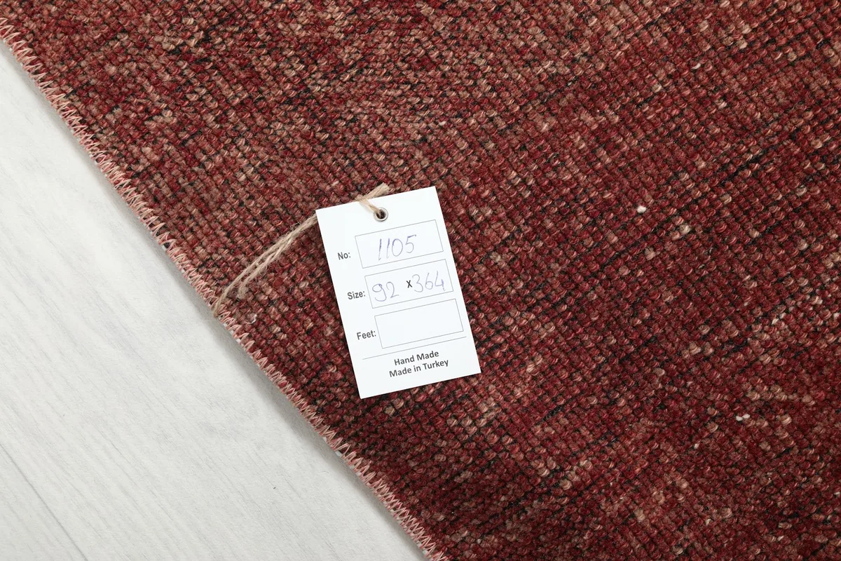 Detail of the rug's tag, indicating its hand-made origin in Turkey and size measurements.