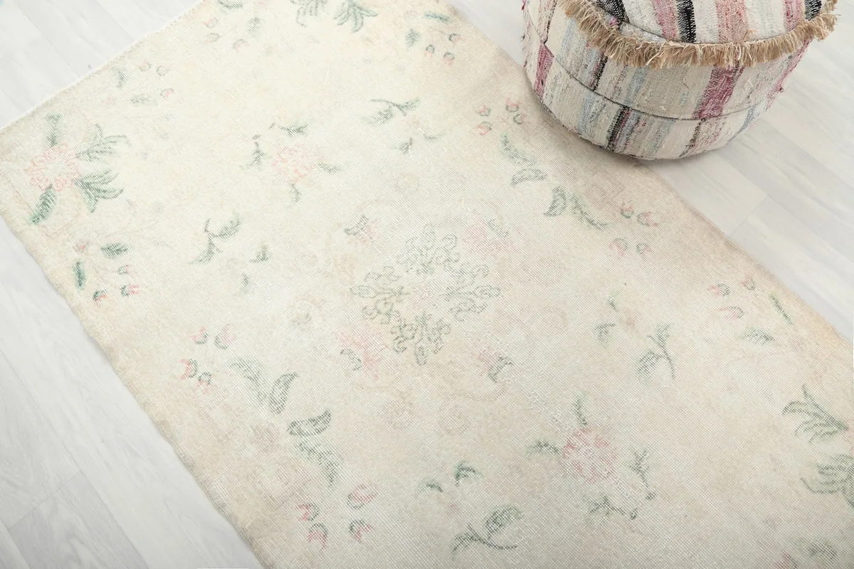 Angled view highlighting the rose and green floral patterns on the ivory field