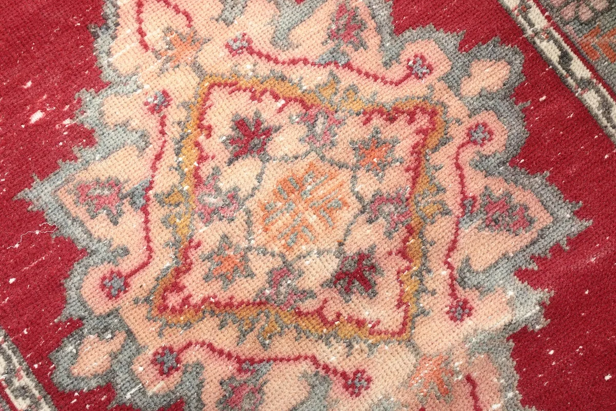 Macro detail of the central geometric medallion, showing the intricate knotting and colors