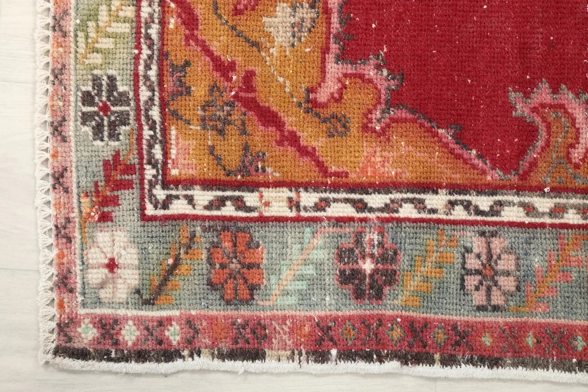 Close-up of the rug's border design, featuring floral motifs and contrasting colors