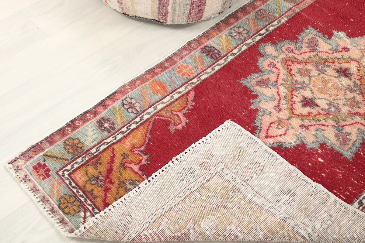 Corner of the rug folded to reveal the cotton foundation and reverse side of the knots