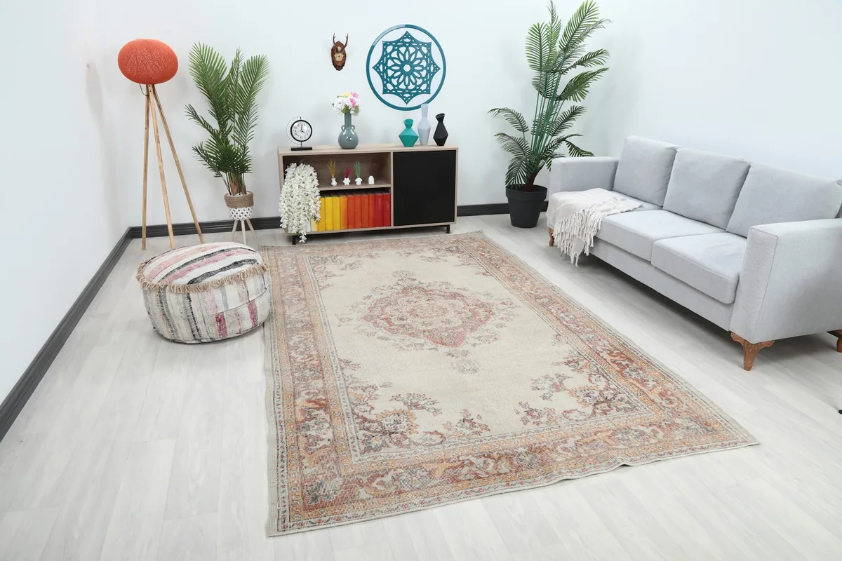 Angle view of the ivory area rug in a modern living space with a striped ottoman