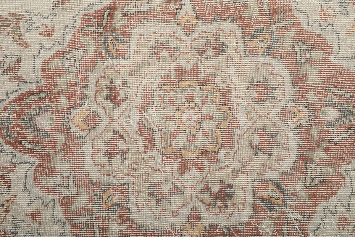 Close-up detail of the central medallion showing the hand-knotted wool pile and colors