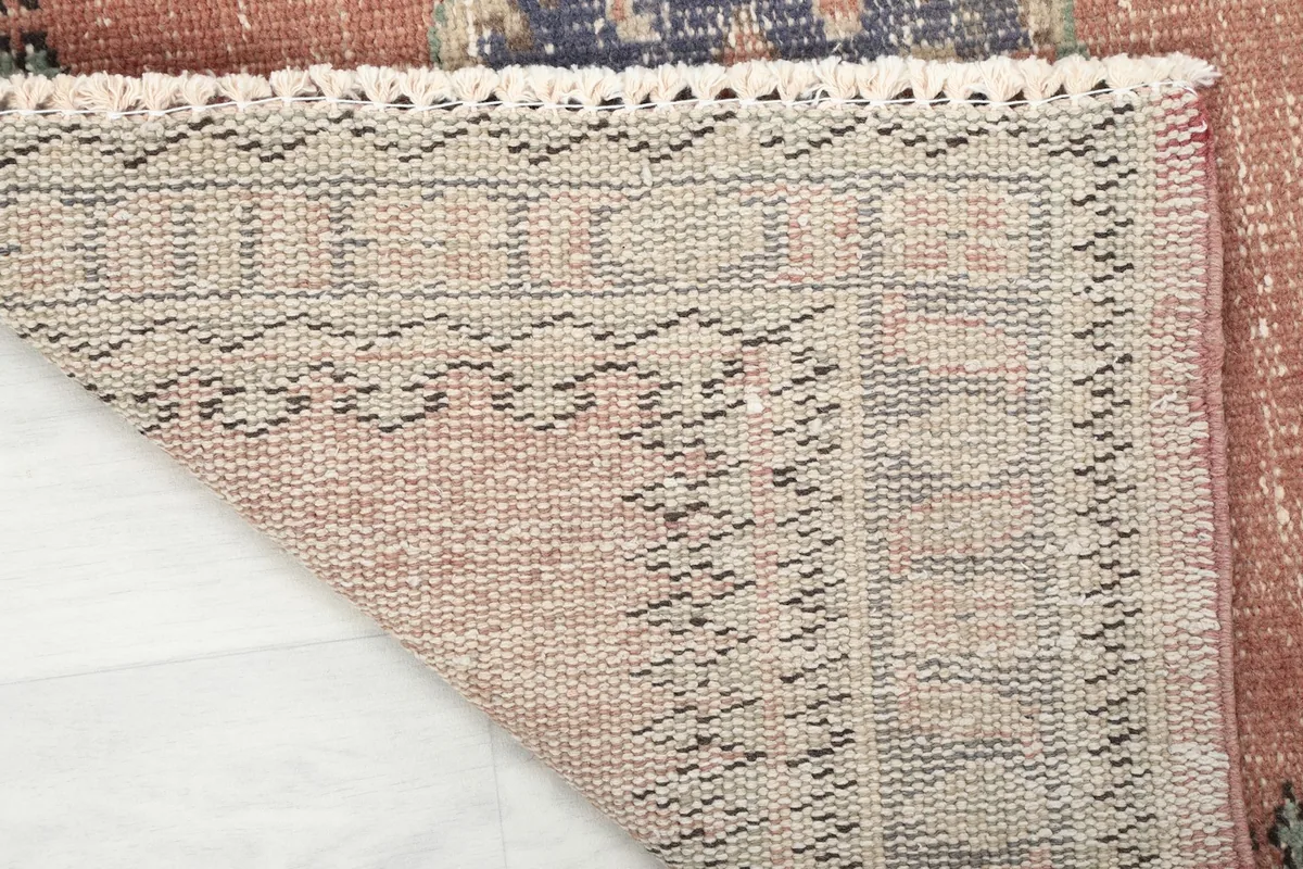 View of the back of the vintage runner rug, highlighting the tight hand-knotted construction and cotton foundation