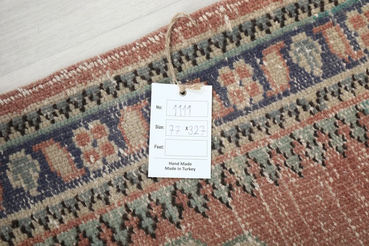 Close-up of the rug's border and a product tag displaying the size in centimeters and 'Hand Made in Turkey'