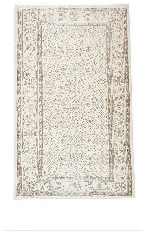 Full top view of the ivory and tan vintage Anatolian rug on a white background