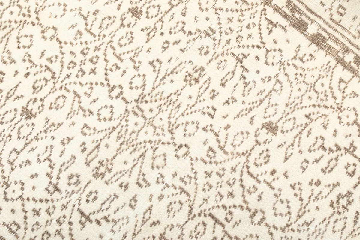 Detailed view of the intricate tan motifs and texture of the rug's pile