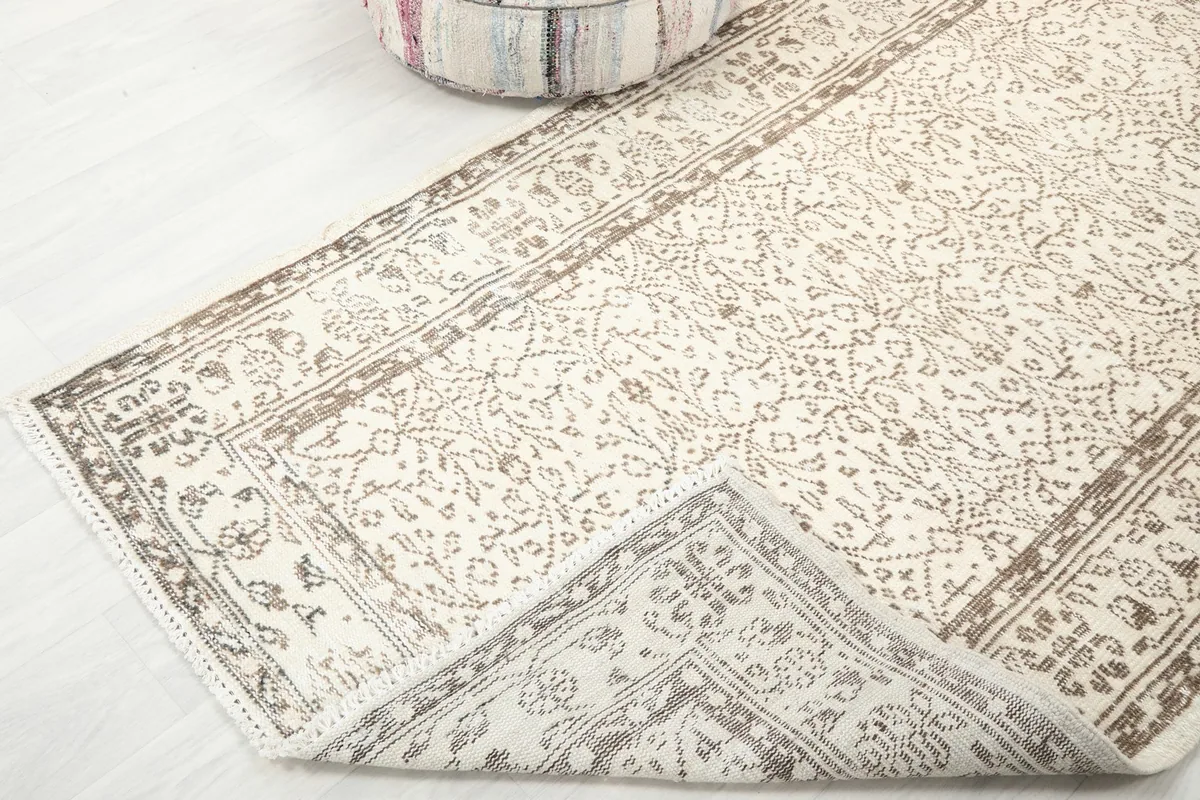 Corner of the rug folded back to reveal the hand-knotted cotton foundation