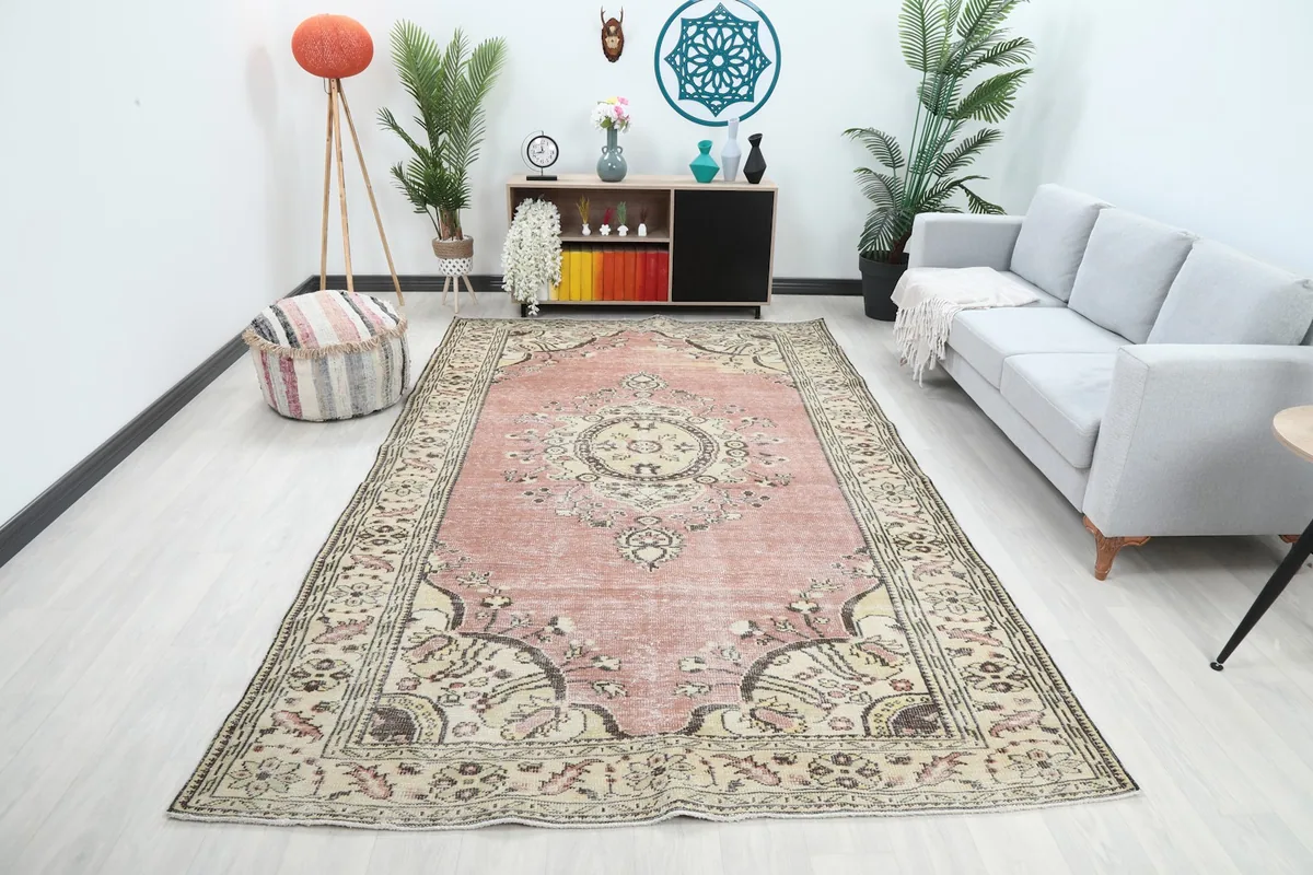 Vintage rose and ivory rug displayed in a bright living room with a gray sofa