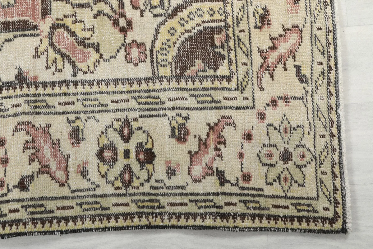 Detailed view of the ivory border with brown and rose floral patterns