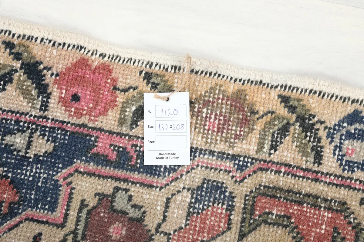 Close-up of the rug's corner with a product tag, showing the detailed weave and fringe.