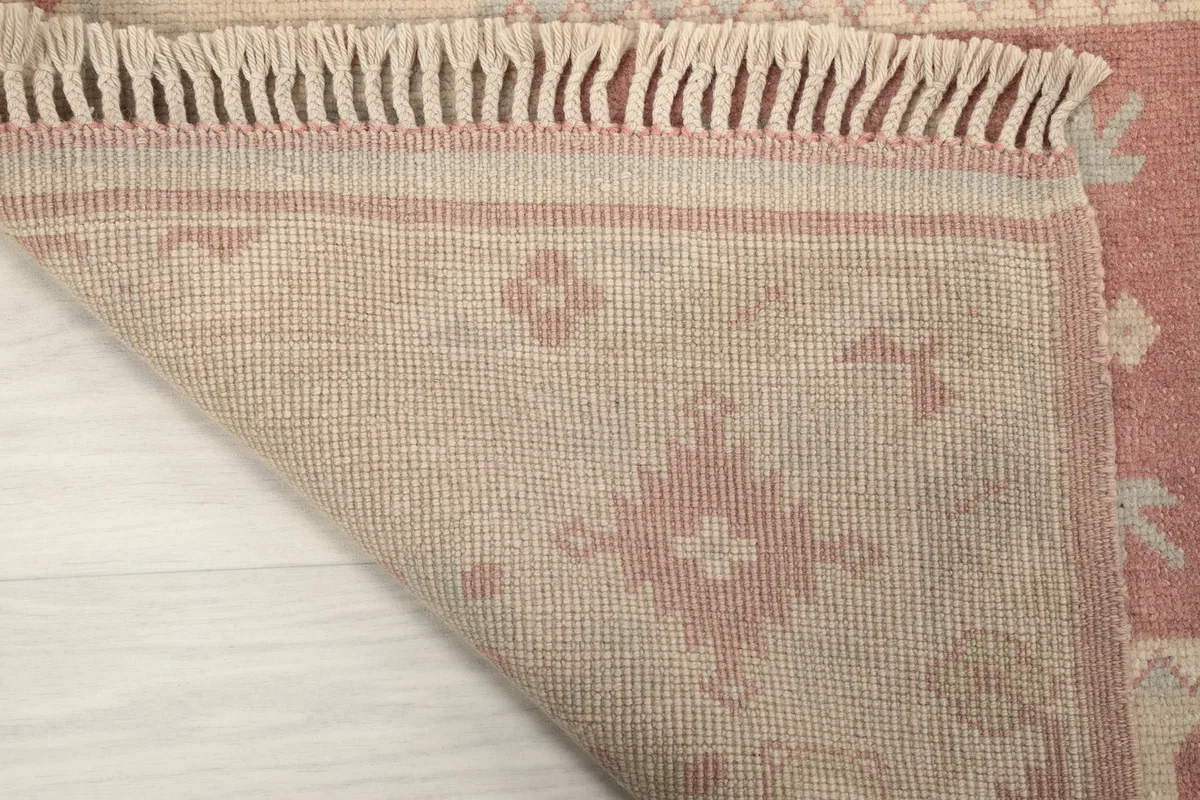 Close-up of the rug's reverse side, showing the hand-knotted construction and cotton foundation.
