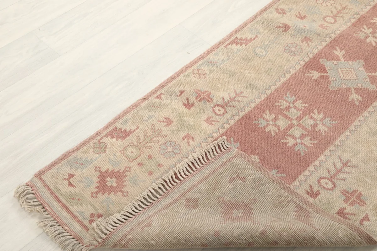 Corner of the runner folded back to reveal the cotton foundation and reverse side.