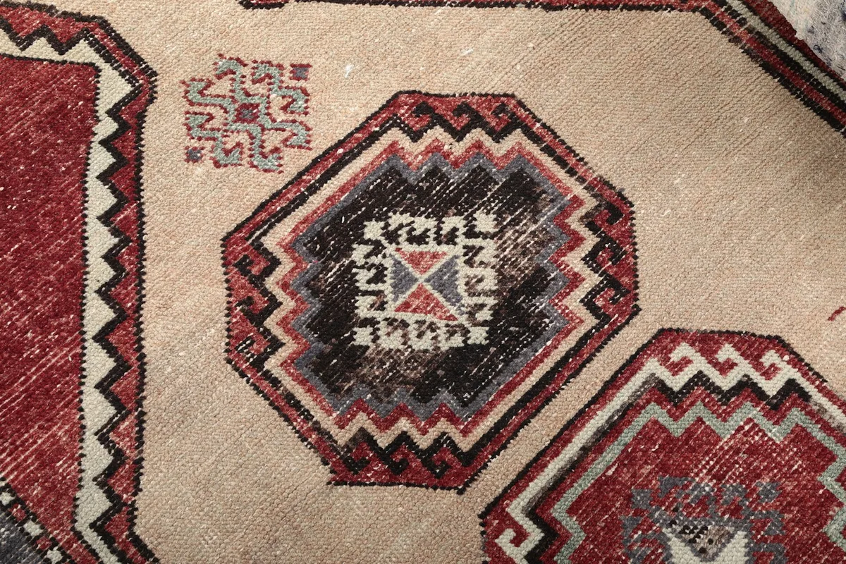 Detailed view of a central geometric medallion, showcasing the intricate black, red, and gray weaving.