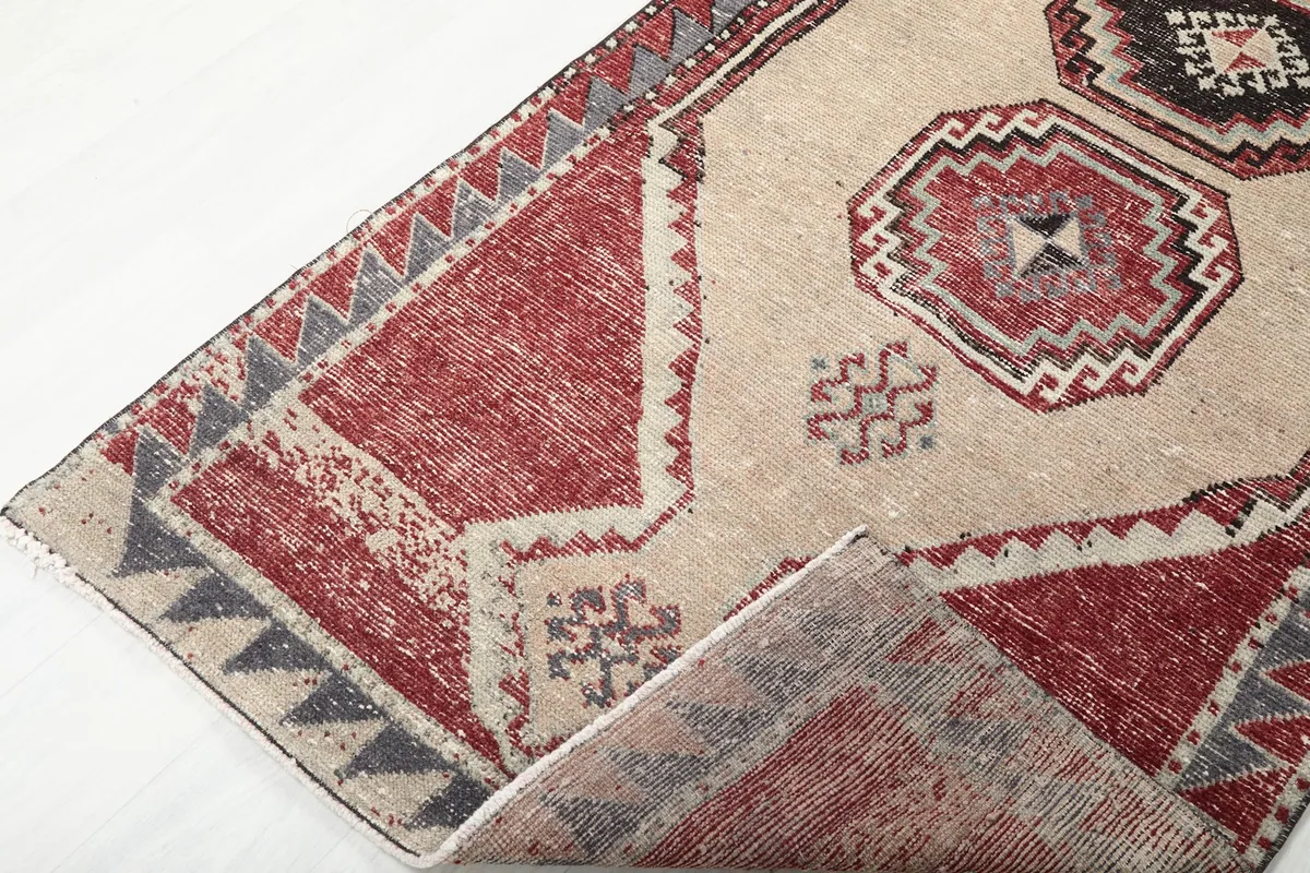 Angled view showing the low wool pile and the hand-knotted texture of the vintage rug.