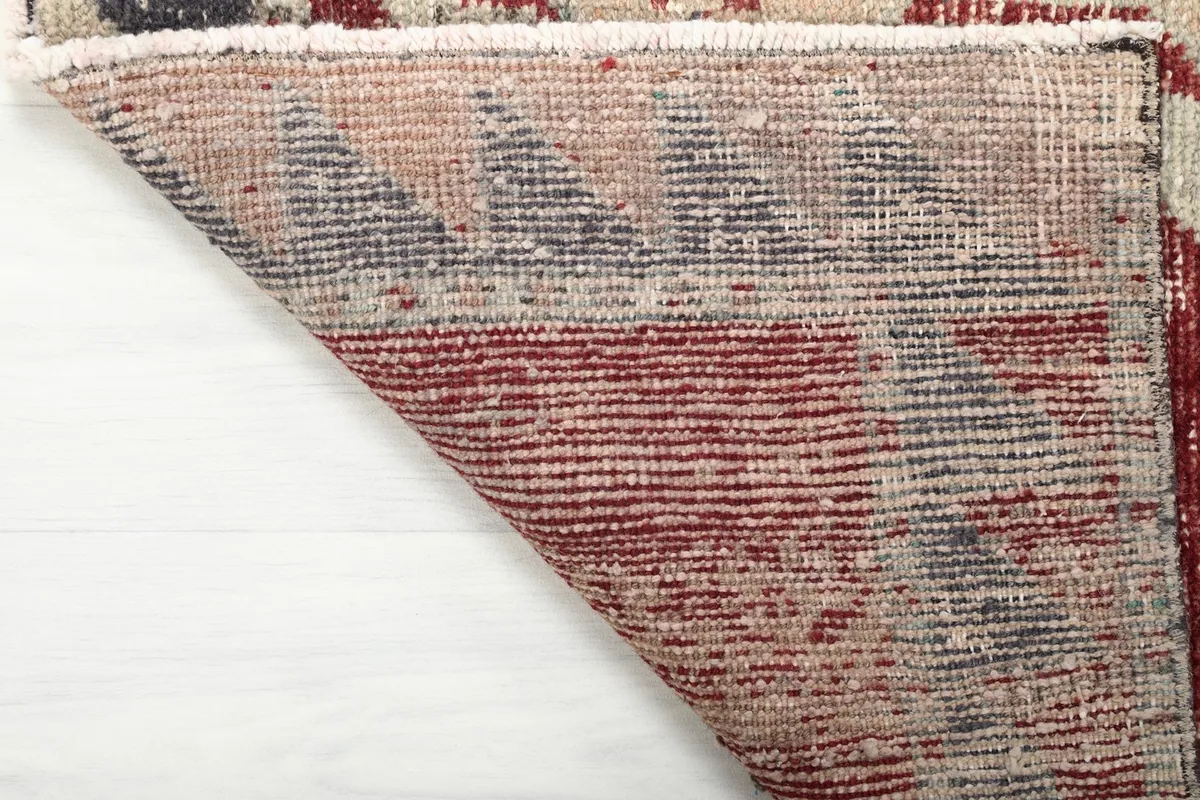Underside of the rug, revealing the cotton foundation and the reverse of the hand-knotted construction.