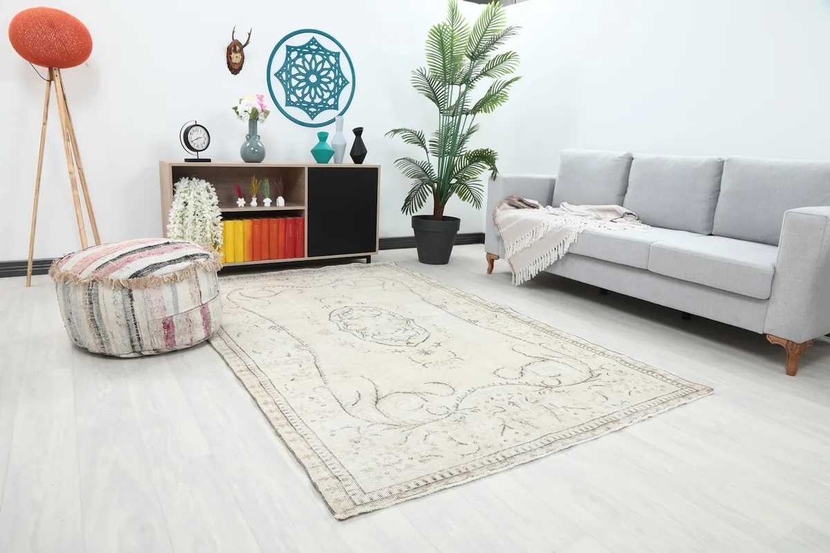 Angle view of the ivory and gray rug in a living room, showing its placement relative to a sofa.