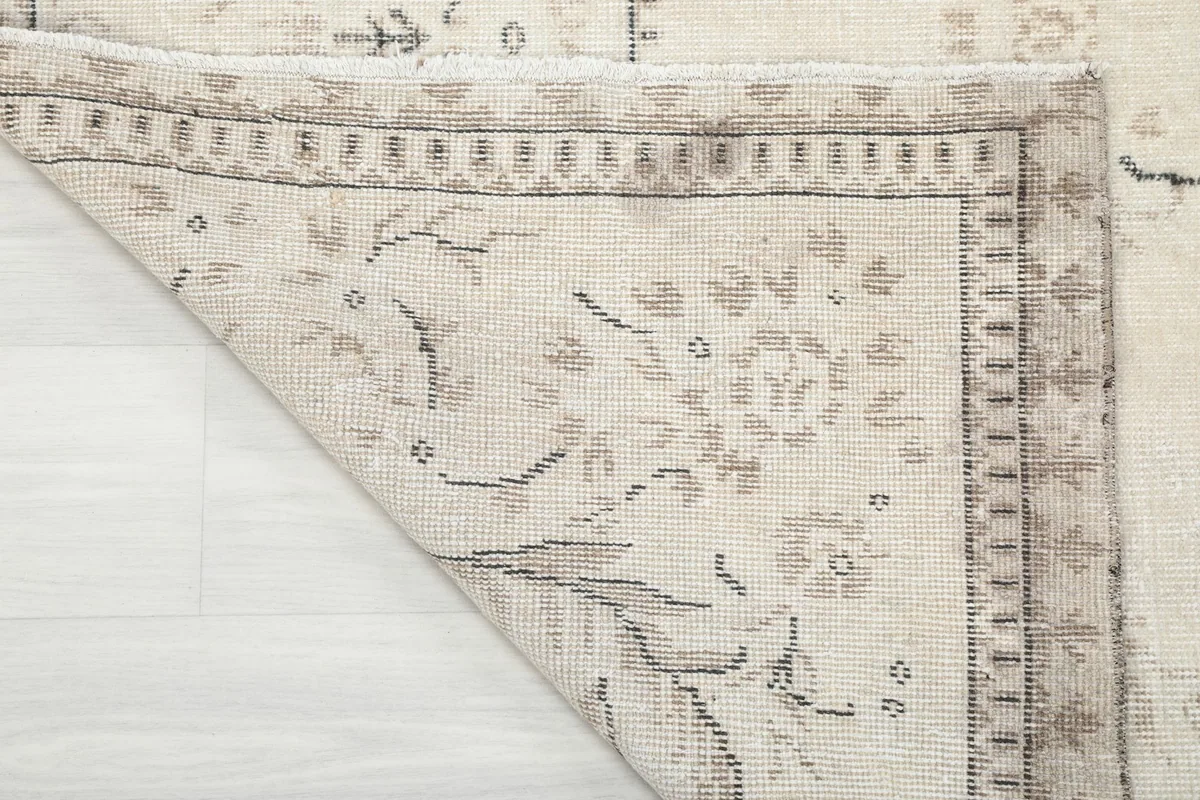 Close-up of the back of the rug, showing the hand-knotted cotton foundation and wool pile.