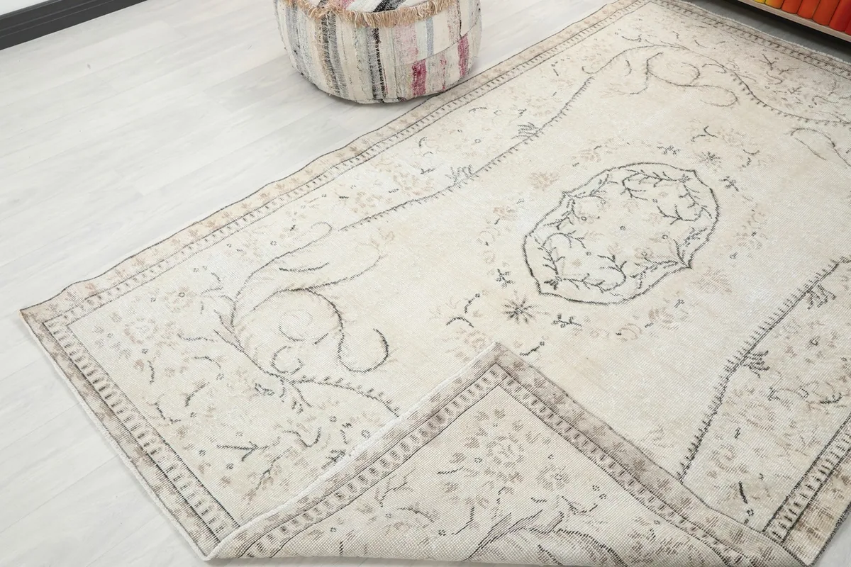 Corner of the rug folded back, revealing the reverse side and knotting detail.