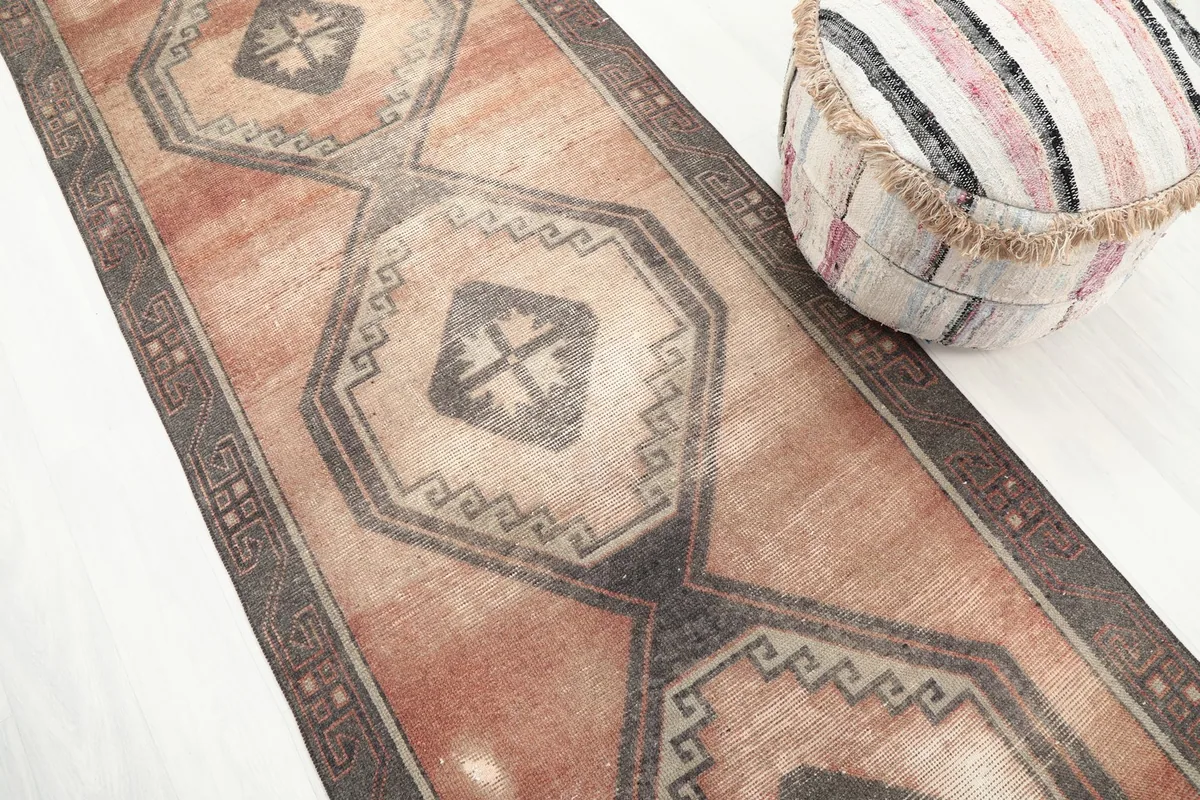 Angled view highlighting the vintage patina on the rust and charcoal runner