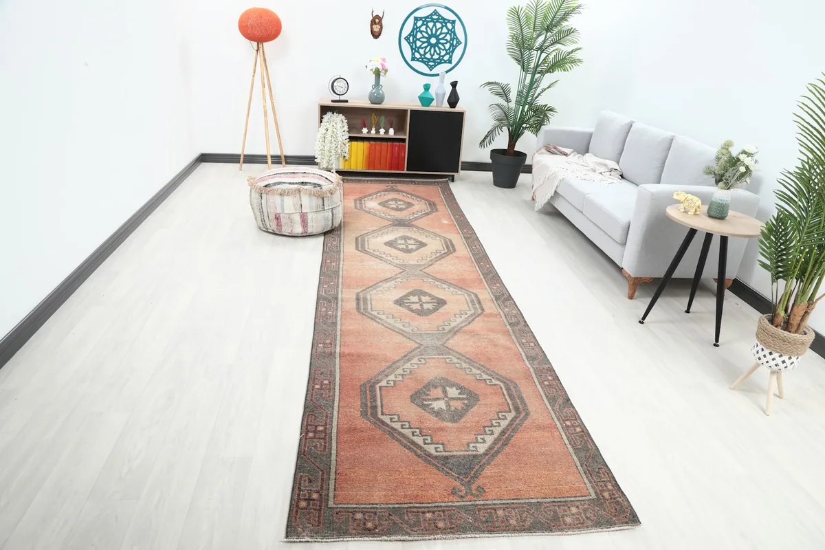 Vintage rust runner rug in a modern living space with a sofa and plant